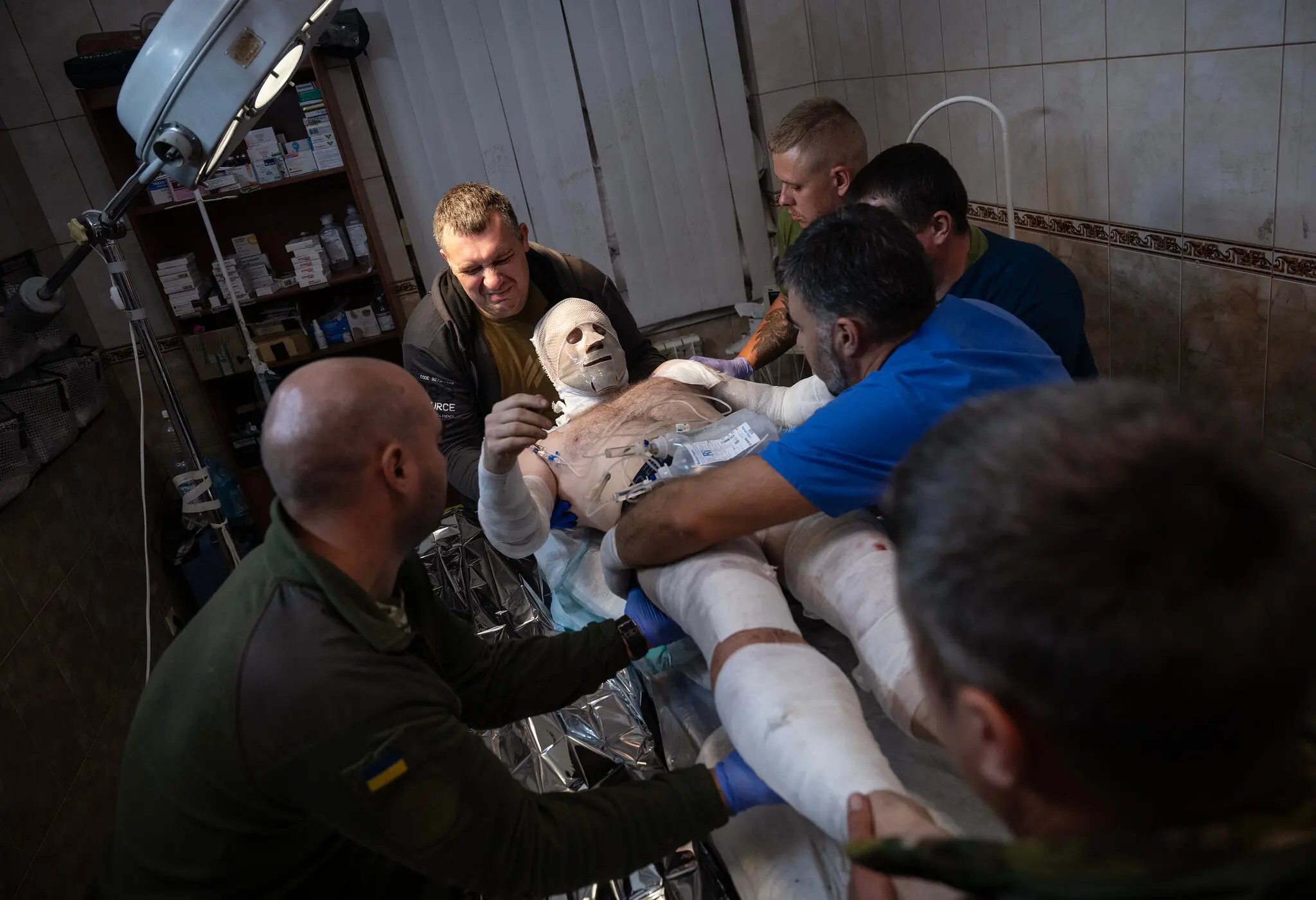 Українські лікарі та медики доглядають пораненого добровольця на стабілізаційному пункті під Бахмутом 9 вересня